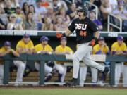 Oregon State's KJ Harrison (24) celebrates his grand slam while rounding the bases as LSU players watch from the dugout in the sixth inning at NCAA College World Series in Omaha, Neb., Monday, June 19, 2017.