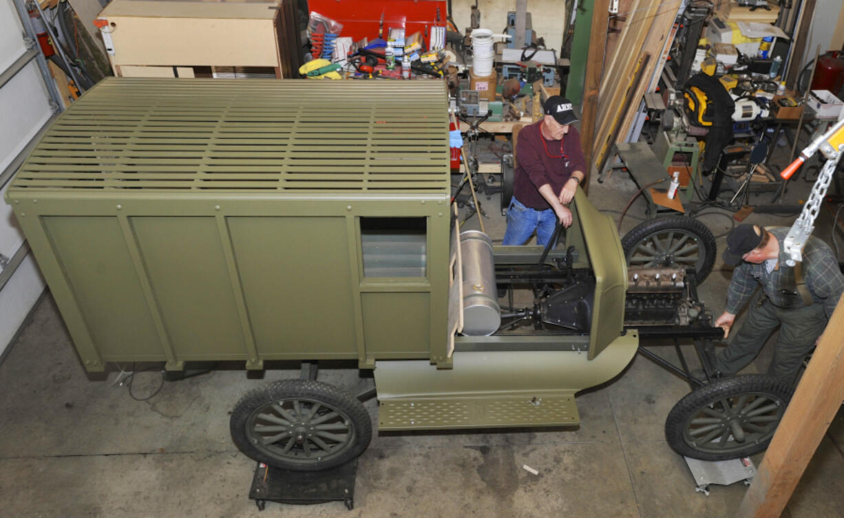 Lyle Wold, left, holds the gear shift lever as Tim Shotwell turns the engine crank of a 1917 Model T Ford the Vancouver Barracks Military Association is transforming into a replica of a World War I Army ambulance.