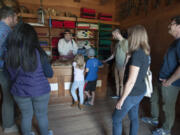 Volunteer Joseph Oleksiewicz, in the black hat, tells Ruby and Henry Fry, at the counter, about the fur trade at Fort Vancouver during their family’s visit in July 2016.