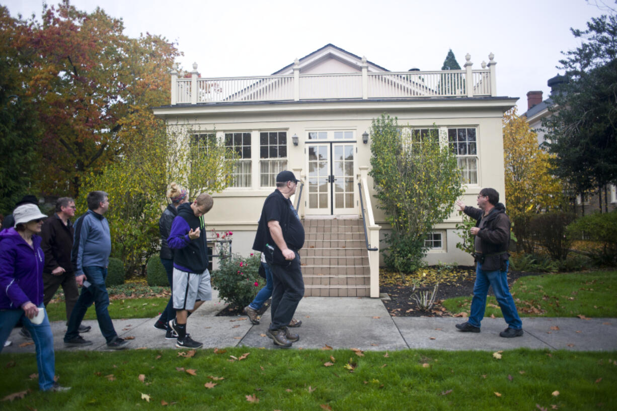 Historian Jeff Davis leads his group past the Red Cross Building in West Vancouver Barracks during a Spirit Tales walking tour in October. Staring Friday, Davis will lead weekend tours through Sept. 4.