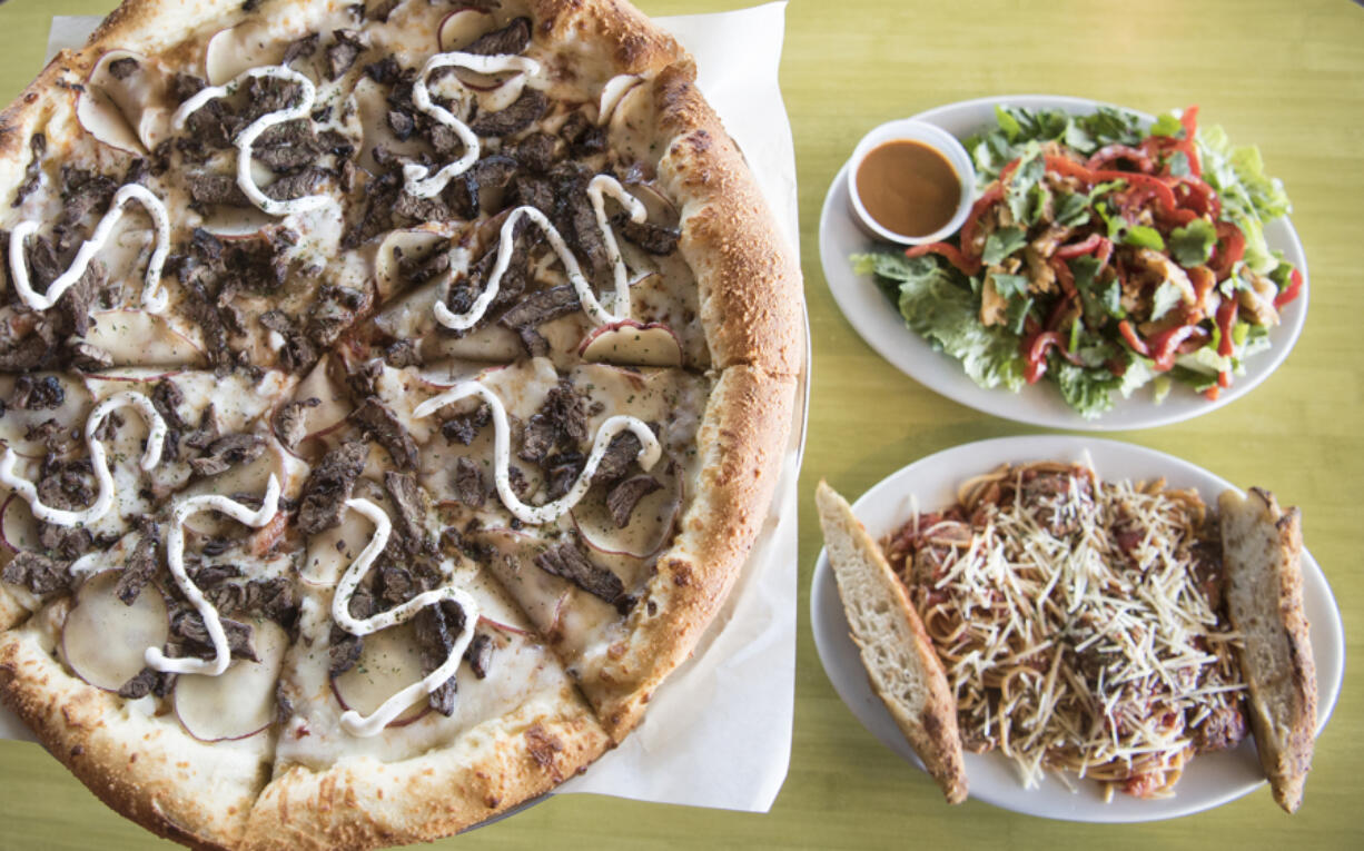 A steak and potato pizza, clockwise from left, Thai chicken salad and spaghetti and meatballs at Schmizza Pub & Grub in Salmon Creek.