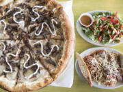 A steak and potato pizza, clockwise from left, Thai chicken salad and spaghetti and meatballs at Schmizza Pub & Grub in Salmon Creek.