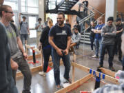 Kinan Badr, center, laughs with other engineering students during an engineering club competition Friday in Clark College’s STEM Building. Badr emigrated from Syria when he was 16 and now, at age 24, is graduating from Clark College. He won a student award for his work with the engineering program.