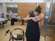 Ginger Meggison of Salmon Creek, center, hugs Lacey Acklin, facing, of Meals on Wheels at the nonprofit’s final lunch Friday at the Firstenburg Community Center. “I’m really going to miss it,” Meggison said.