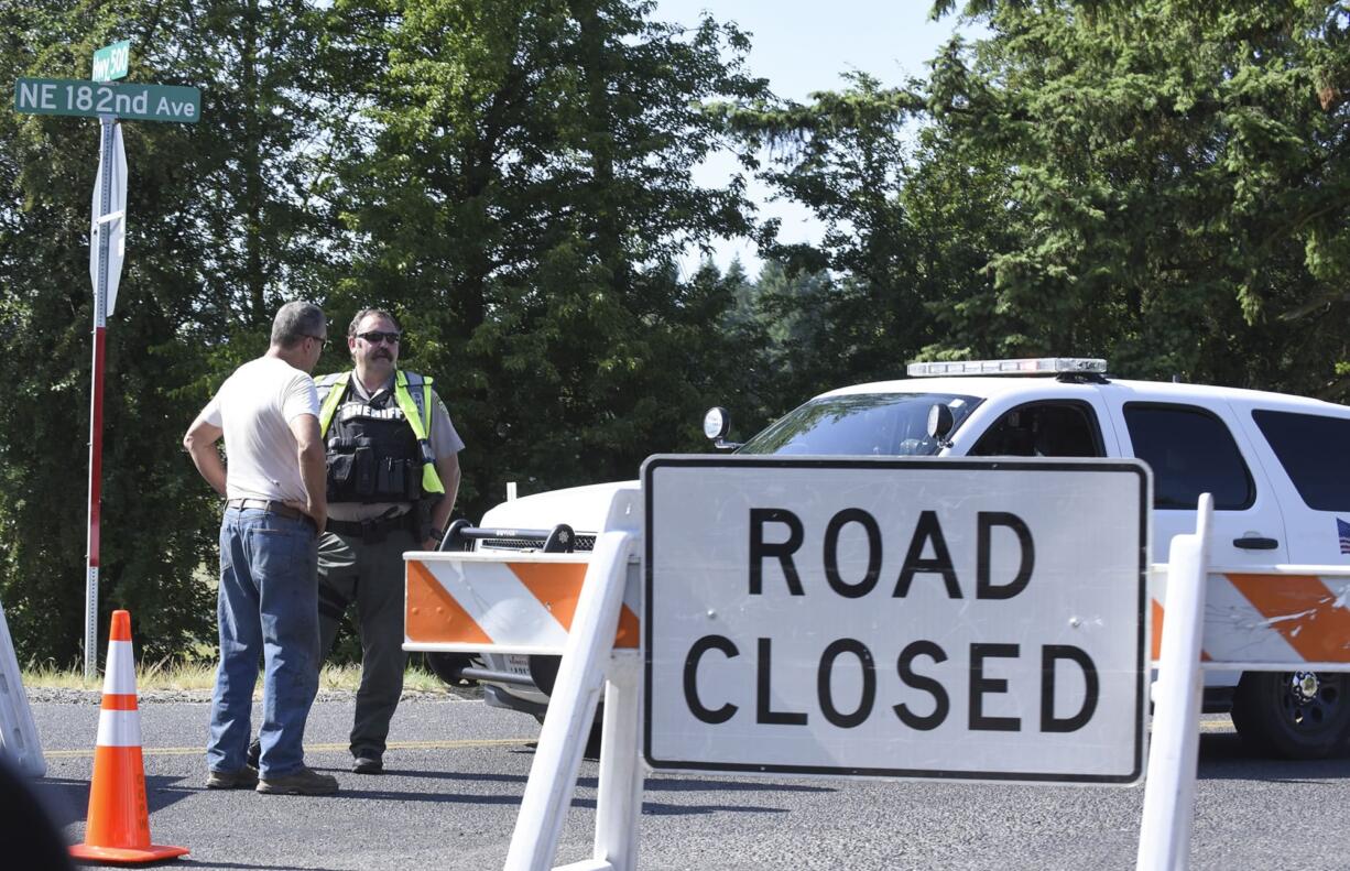 Clark County sheriff’s deputies direct traffic away from Northeast 182nd Avenue at Fourth Plain Road after a bank robbery suspect was shot and killed after he traded gunfire with police. The man allegedly robbed the iQ Credit Union at 15705 N.E. Fourth Plain Blvd. No officers were injured.