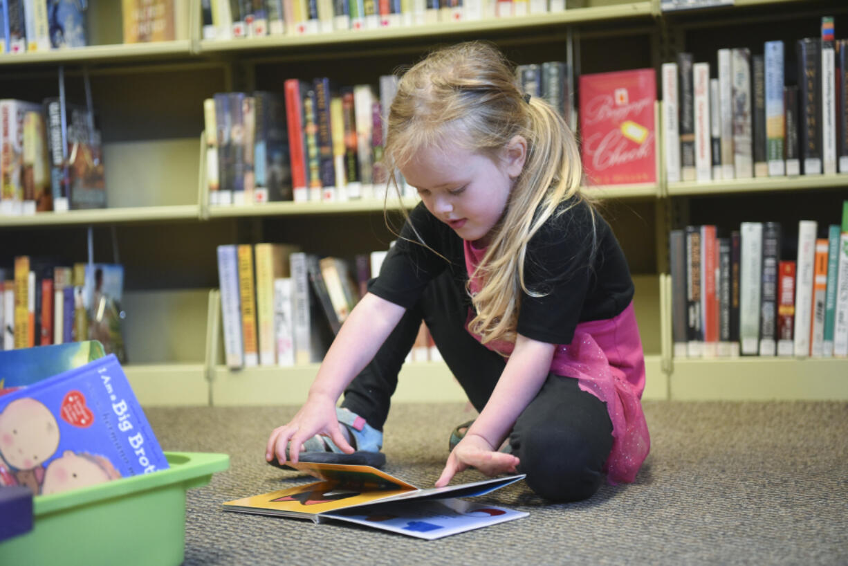 Young reader Alleyah Sansburn turns the page on a book at the Yacolt Library Express in Yacolt on May 30. The 4-year-old will be able to participate in Fort Vancouver’s summer reading program when it starts Thursday.