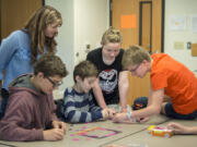 Prevention and intervention specialist Kari Koller, standing in blue, works with Prevention Club members Ray Miller, 13, from left, Gabe Slaton, 13, Natasha Young, 12, and Sydney Wheaton, 12, during a meeting of the Prevention Club at Chief Umtuch Middle School in Battle Ground on May 26.