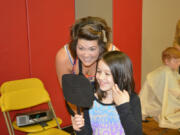 Washougal: Emily Thompson of Urban Style, left, shows Hathaway Elementary School first-grader Izzabella Lucus her new haircut, which Izzabella received during the second Hathaway Elementary School Booster Club Cuts for Kids program.