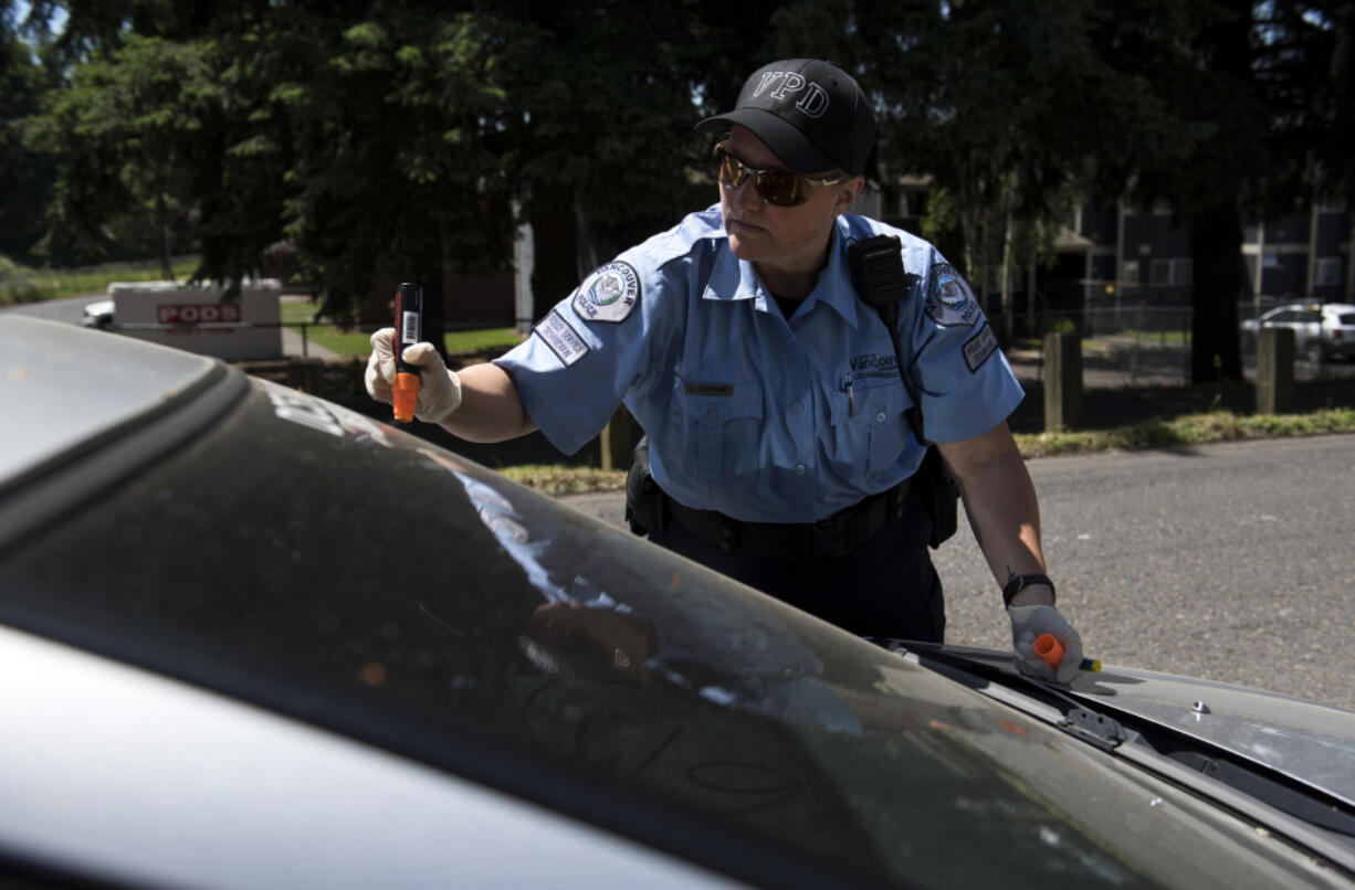 Vancouver police service technician Julie Cleveland tags an abandoned vehicle in northeast Vancouver. The Vancouver Police Department recently put police service technicians on patrol to respond to low-level calls in the field.