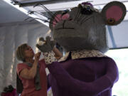 Volunteer Nancy Lyttle of Battle Ground attaches a ring decorated with quartz, seaweed, and coconut dust on the parade float’s Miss Mouse at Battle Ground’s Flex-Use building May 31. Around 50 volunteers have been working since early April to construct the Battle Ground parade float for the Portland Rose Festival Grand Floral Parade on June 10.