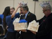 Wy’east Middle School eighth-grader Lillian Kates, from left, presents music teachers Mark Neshyba and Pete Boule with gifts from the eighth-grade class during the duo’s retirement celebration at the school on Tuesday. The eighth-grade class declared the teachers “Kings of Wy’east” in honor of their combined 56 years of teaching at the school. Both retire this year.