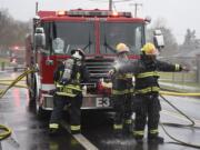 Members of the Vancouver Fire Department clean off after putting out a fire in March.