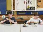 Sam Corio, 13, left, and Emily Rodengren, 10, make careful adjustments Tuesday to rings they made in a metal arts class at Art College, a summer camp at Clark College for students ages 9-14.