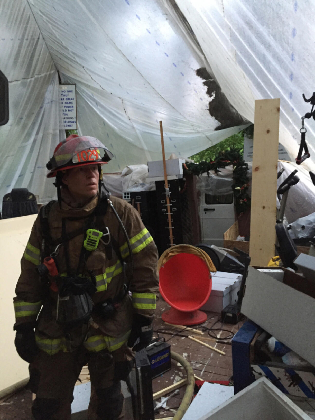 Clark County Fire & Rescue Capt. David Greenwood examines the tarp-enclosed area of a community space that caught fire Thursday night near La Center.