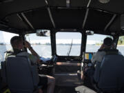 Clark County sheriff’s deputies Brett Anderson, left, and Todd Baker, right, use binoculars to check for up-to-date tags on jet skis while patrolling the Columbia River. Clark County marine deputies will be joining Portland area law enforcement in an emphasis this weekend focused on finding those choosing to drink and boat.