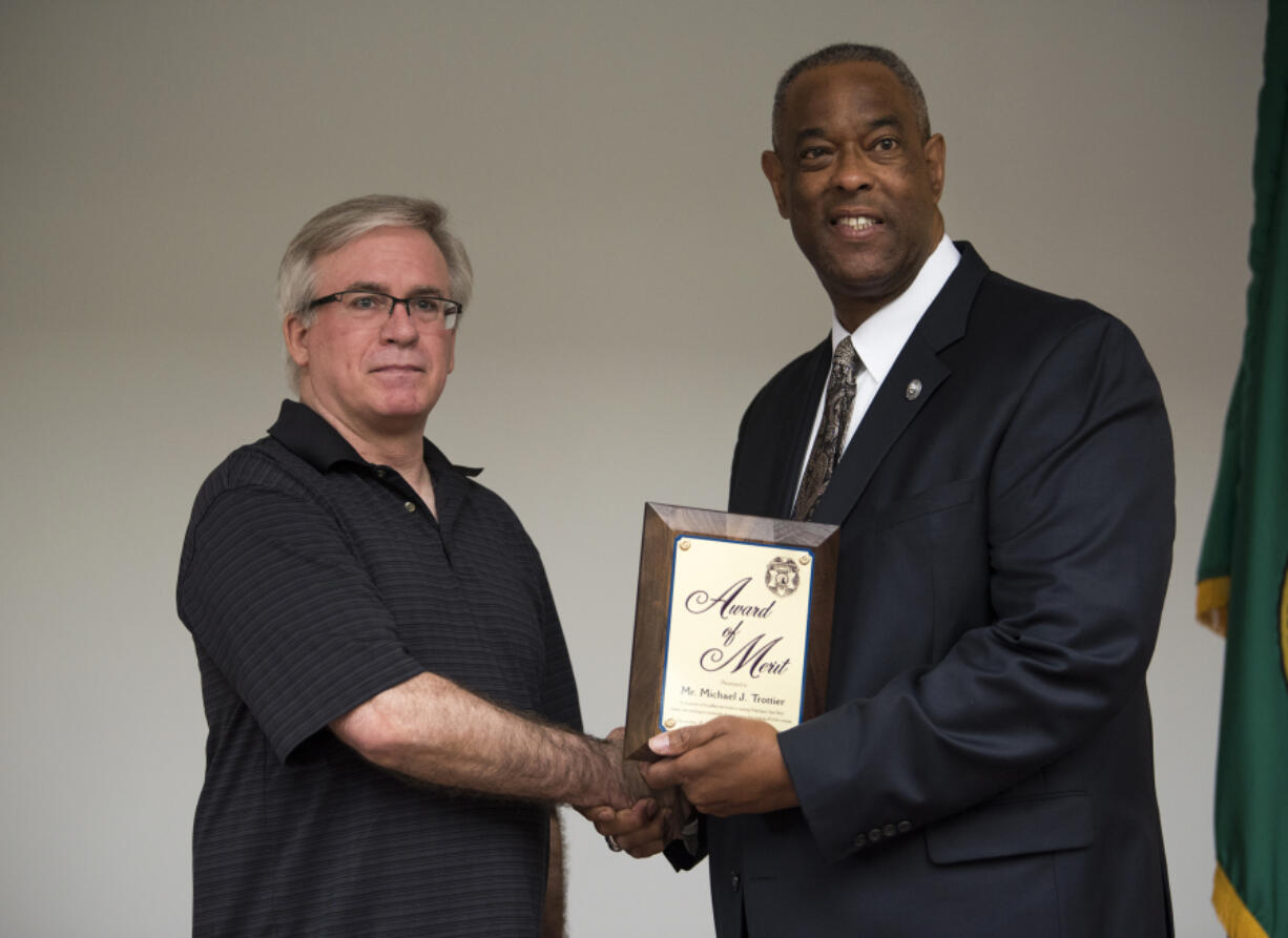 Michael Trottier, left, is presented an Award of Merit by Washington State Patrol Chief John R. Batiste during an awards ceremony at the WSP District 5 Headquarters in Vancouver on Friday. Trottier was on his way to work when he stopped to help a trooper with an emotionally distressed person attempting to jump from the state Highway 500 overpass near Interstate 5.