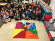 Fircrest: Lara Alford and her Fircrest Elementary School fourth-graders with a mural made from recycled bottle caps. The students made the mural to show the importance of equality, as well as taking care of the environment.