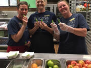 Five Corners: Sunset Elementary School food service staffers, from left, Shana Hysmith, Debbie Phares and Terri Lutz holding up snap peas, this month’s featured food through Washington State University Extension’s Supplemental Nutrition Assistance Program Education’s Harvest of the Month campaign.