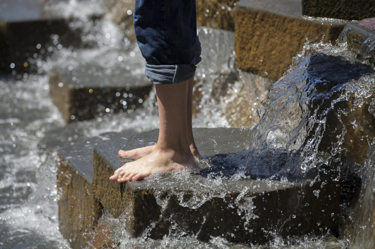 Bare feet and rolled-up jeans were in style as visitors cooled off at Esther Short Park late Friday morning. After a scorcher of a weekend. temperatures hit 100 degrees on Sunday, setting a record.