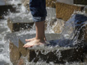 Bare feet and rolled-up jeans were in style as visitors cooled off at Esther Short Park late Friday morning. After a scorcher of a weekend. temperatures hit 100 degrees on Sunday, setting a record.