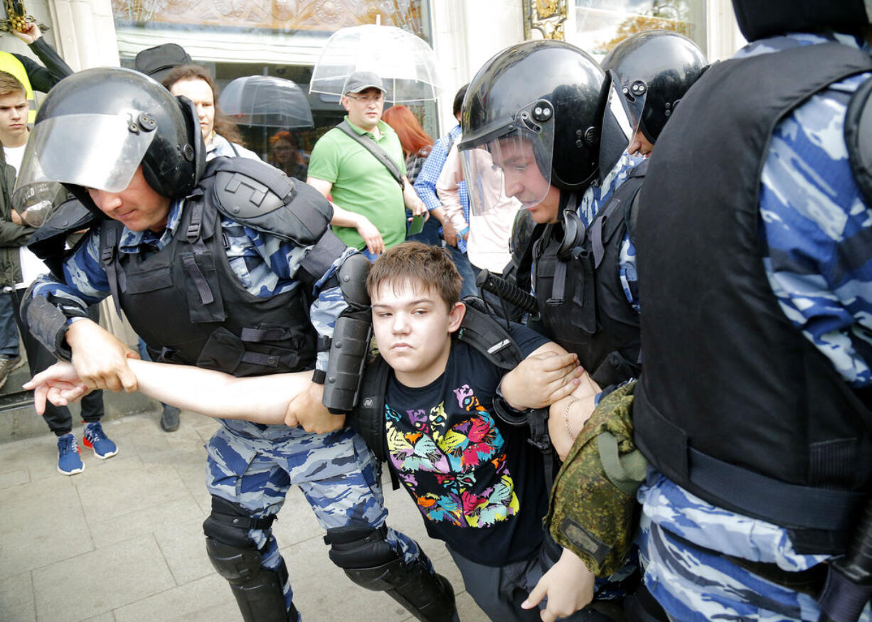 A young demonstrator is apprehended by riot police during a demonstration in downtown Moscow, Russia, Monday, June 12, 2017. Russian opposition leader Alexei Navalny, aiming to repeat the nationwide protests that rattled the Kremlin three months ago, has called for a last-minute location change for a Moscow demonstration that could provoke confrontations with police.