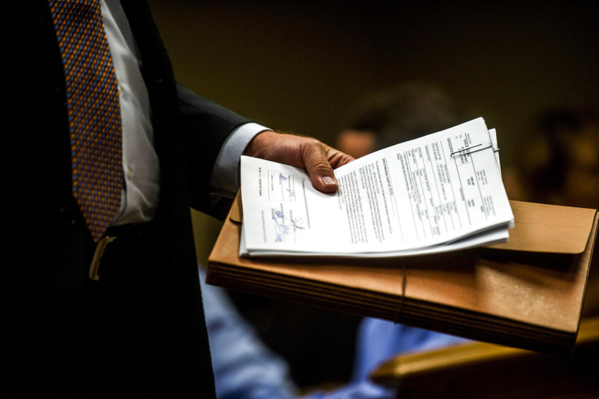 Special Agent Jeff Seipenko walks out of the courtroom with signed paperwork in hand after Genesee District Judge David Guinn authorized charges Wednesday, June 14, 2017, in Flint, Mich., for Department of Health and Human Services Director Nick Lyon and Chief Medical Executive Dr. Eden Wells in relation to the Flint water crisis. Lyon is accused of failing to alert the public about an outbreak of Legionnaires' disease in the Flint area, which has been linked by some experts to poor water quality in 2014-15. Wells was charged with obstruction of justice and lying to a police officer.