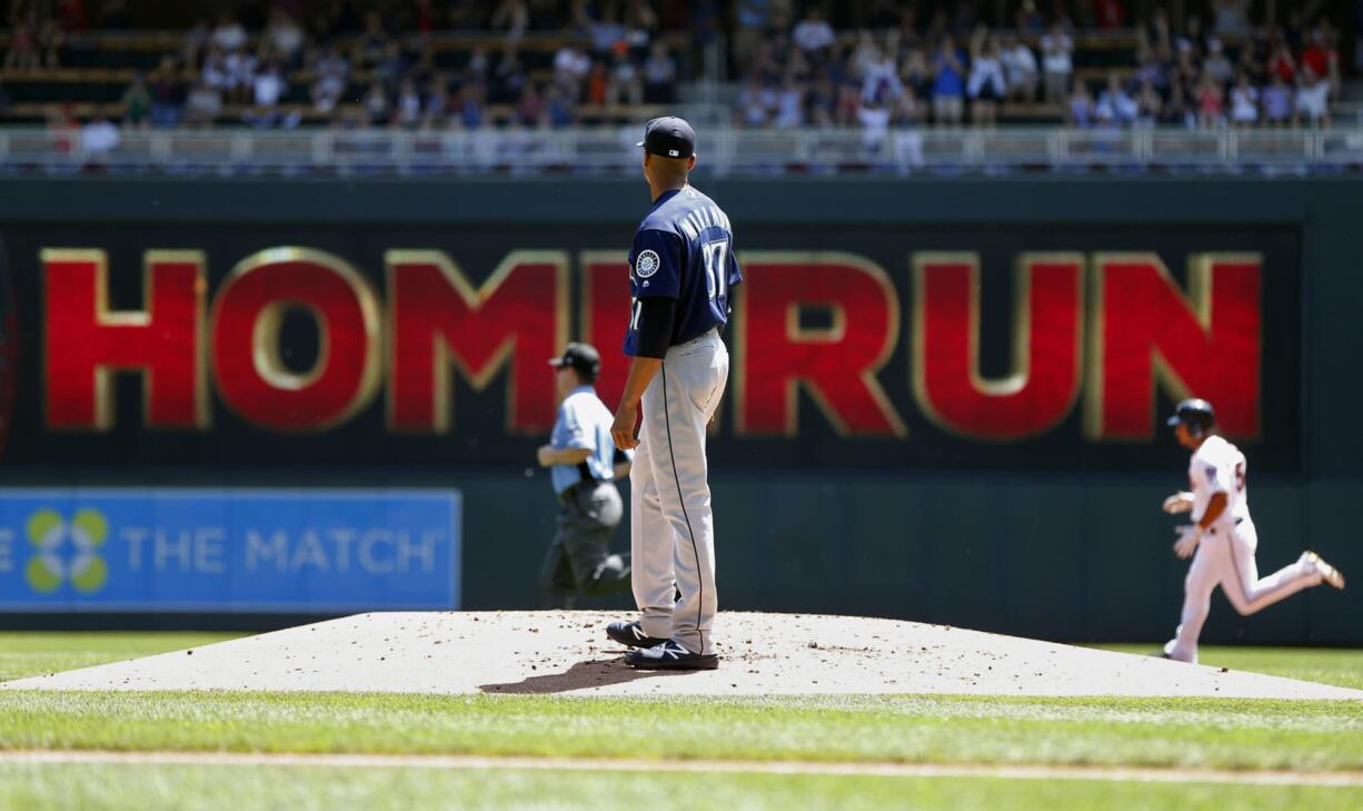 Seattle Mariners pitcher Ariel Miranda looks back after he gave up a two-run home run to Minnesota Twins' Eduardo Escobar, right, in the first inning of a baseball game Thursday, June 15, 2017, in Minneapolis.