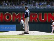 Seattle Mariners pitcher Ariel Miranda looks back after he gave up a two-run home run to Minnesota Twins' Eduardo Escobar, right, in the first inning of a baseball game Thursday, June 15, 2017, in Minneapolis.