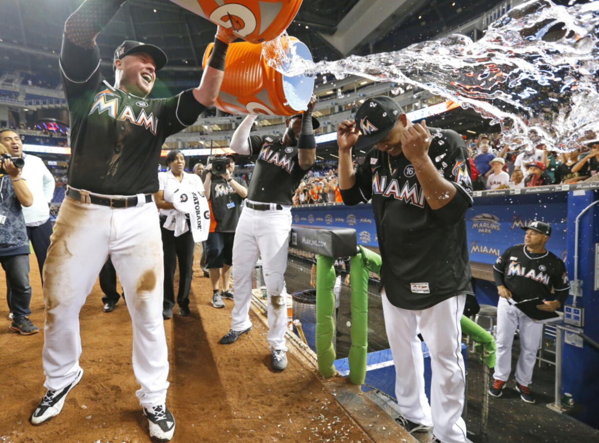 Miami Marlins’ Justin Bour, left, and Marcell Ozuna, center rear, pour ice and water onto starting pitcher Edinson Volquez, right, after he threw a no-hitter against the Arizona Diamondbacks Saturday in Miami.