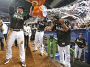 Miami Marlins’ Justin Bour, left, and Marcell Ozuna, center rear, pour ice and water onto starting pitcher Edinson Volquez, right, after he threw a no-hitter against the Arizona Diamondbacks Saturday in Miami.