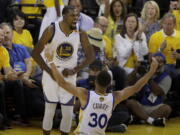 Golden State Warriors forward Kevin Durant (35) celebrates with guard Stephen Curry (30) Game 2 of the NBA Finals on Sunday. Curry had 32 points, 11 assists and 10 rebounds, while Durant contributed 33 points, 13 rebounds and six assists.