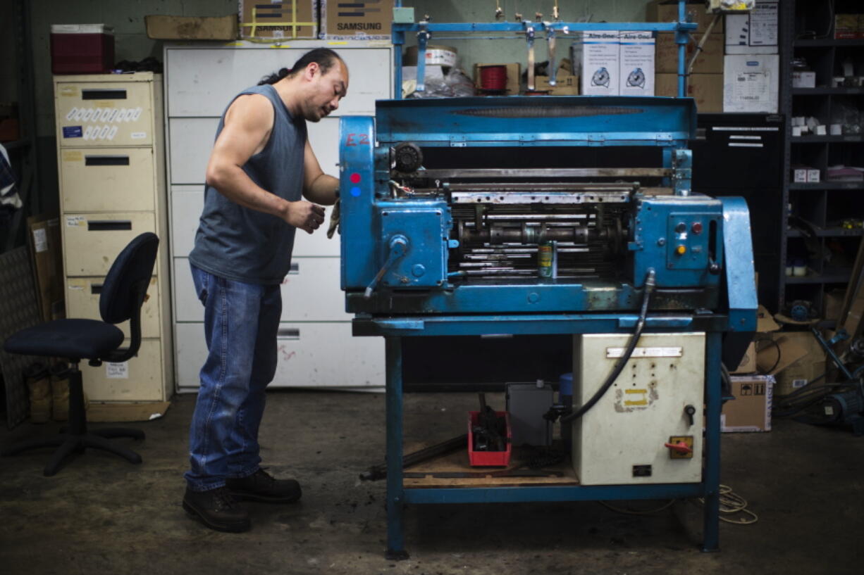 Hien Nguyen works on a knitting machine.