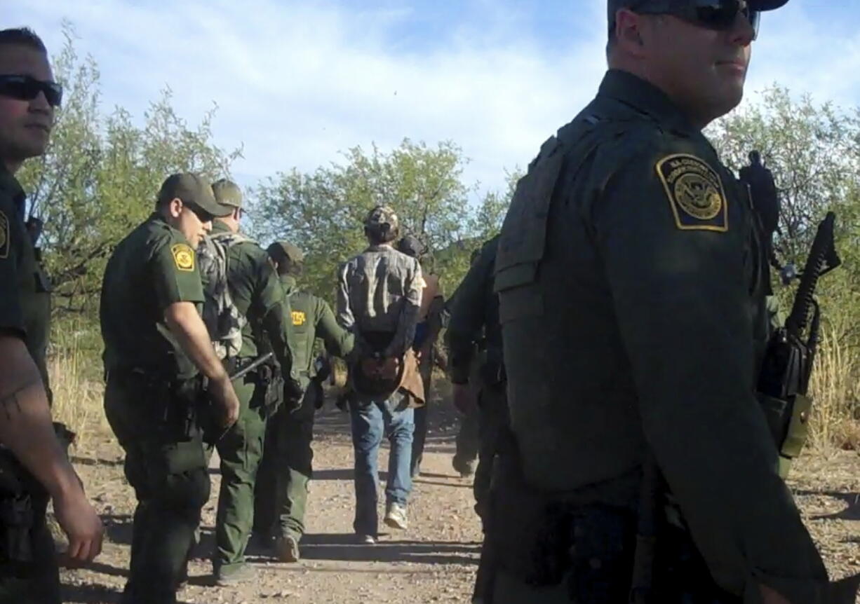 This Thursday June 15, 2017, photo provided by No More Deaths/No Mas Muertes, an organization that provides care for migrants along the Mexican border, shows Border Patrol agents detaining an unidentified person in the Arizona desert. Border Patrol agents descended on the medical camp set up in the Arizona desert near the border to provide refuge and water for migrants in the scorching summer heat, arresting four men who were receiving aid after spending several days in the desert.