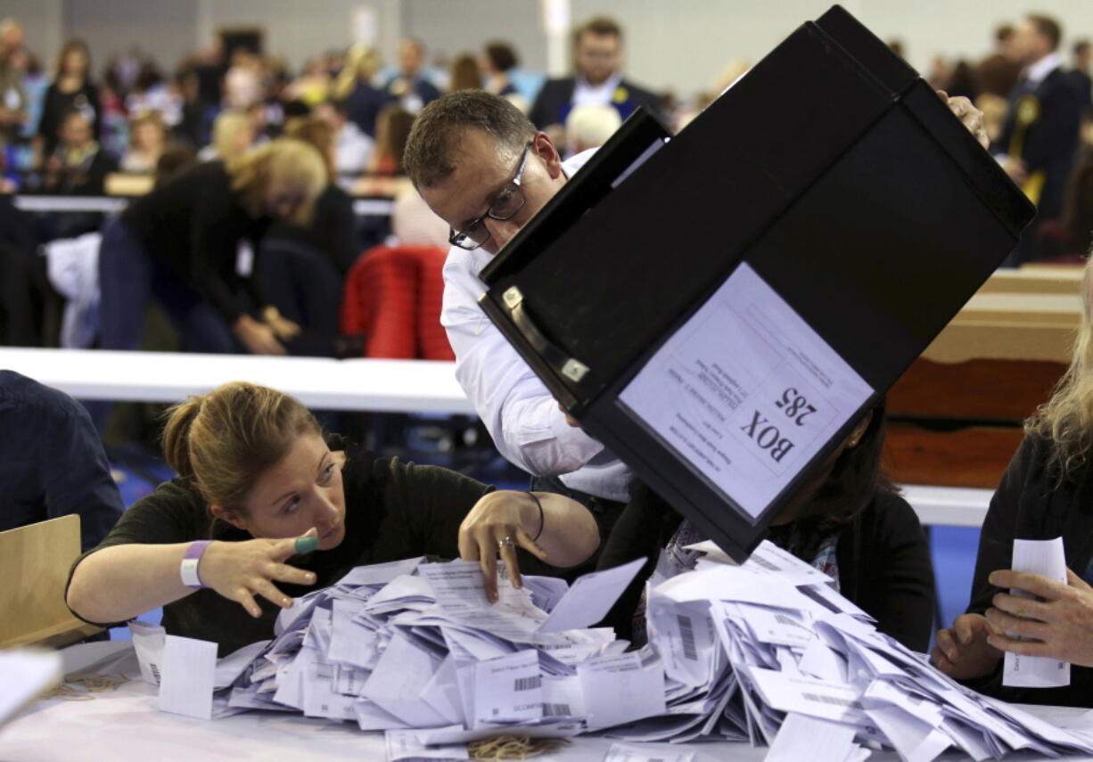 Ballot boxes are emptied of ballots to be counted Thursday in Glasgow, Scotland, in Britain’s general election.