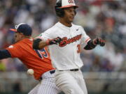 Cal State Fullerton first baseman Dillon Persinger (19) cannot reach the throw and Oregon State's Preston Jones (33) — a Mountain View High graduate — continues to second base on the throwing error in the seventh inning of the College World Series game in Omaha, Neb., Saturday, June 17, 2017.