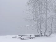 Snow covers a picnic table Monday at Serene Lakes, near Soda Springs, Calif.