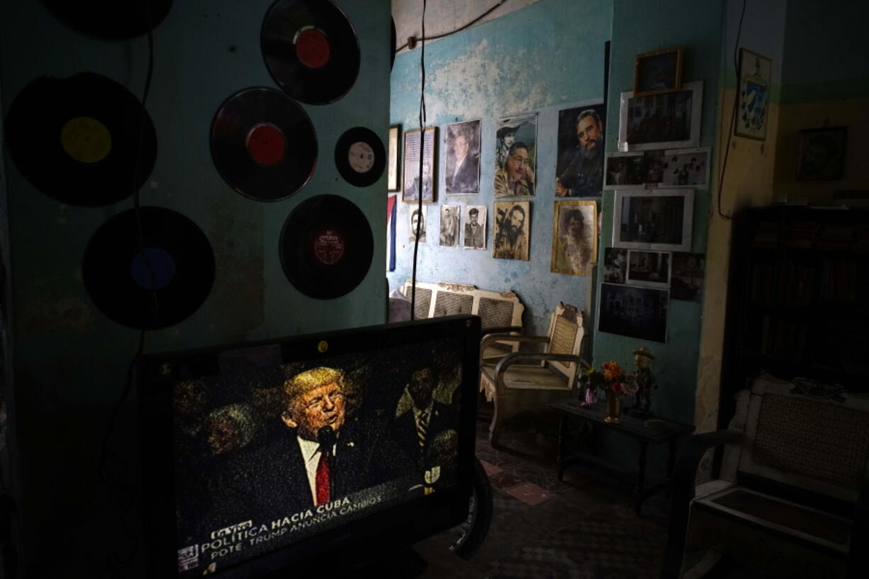 A television shows President Donald Trump announcing his new Cuba policy Friday in a home in Havana, Cuba, decorated with images of Cuban leaders.