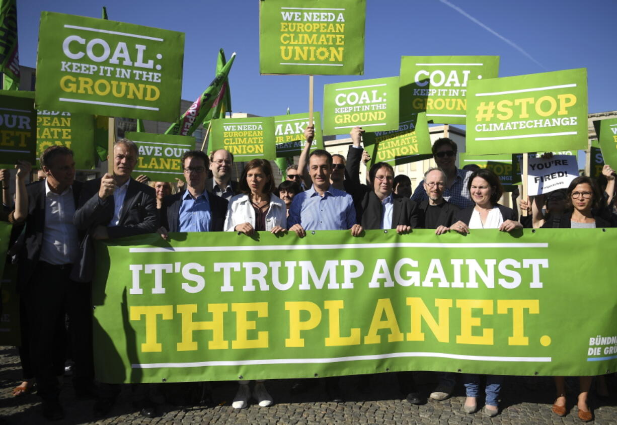 Candidates of the Green Party in Germany’s parliamentary elections, Katrin Goering-Eckardt, center left, and Cem Ozdemir, center, protest President Trump’s decision to exit the Paris climate agreement in front the U.S. Embassy on Friday in Berlin.