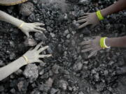 Indian women pick reusable pieces from heaps of used coal discarded by a carbon factory in Gauhati, India.