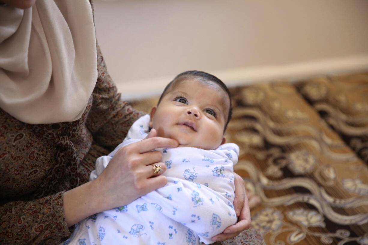 Samah Hamidi, 25, holds her three-month old son Leith in her family home in Irbid, Jordan on Thursday, June 29, 2017. The family fled the Syrian war in 2012 for Jordan and was in the resettlement pipeline to the U.S. when President Donald Trump’s executive order stalled the process. Once sure of his future in the U.S., her hisband, al-Haj Ali had quit his job, sold the furniture and rented an apartment in the city of Rockford near his uncle’s home in Illinois. The family still has five suitcases packed but has scant hope for resettlement in America.