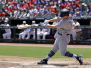 Seattle Mariners' Kyle Seager follows through on a run-scoring double off a pitch from Texas Rangers' Yu Darvish during the first inning of a baseball game, Sunday, June 18, 2017, in Arlington, Texas.