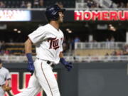 Minnesota Twins' Eddie Rosario jogs home on a solo home run off Seattle Mariners' Carlos Ruiz, left, during the eighth inning of a baseball game Tuesday, June 13, 2017, in Minneapolis. The Twins won 20-7. Rosario went 4-for-5 with three home runs and five RBIs. Ruiz, a catcher, was called to pitching duty in the eighth.