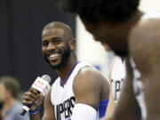 FILE - In this Sept. 26, 2016, file photo, Los Angeles Clippers' Chris Paul laughs as he, Blake Griffin and DeAndre Jordan, right, talk during the team's NBA basketball media day, in Playa Vista, Calif. The Houston Rockets have reached an agreement to trade for Los Angeles Clippers point guard Chris Paul according to a person familiar with the deal.