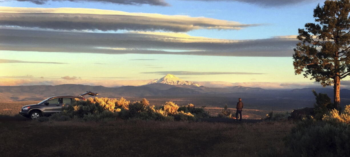 Joe Krenowicz, executive director of the Madras-Jefferson County Chamber of Commerce, looks toward Mt. Jefferson as the sun rises over Madras, Ore., on June 13. The first place to experience total darkness as the moon passes between the sun and the Earth will be in Oregon, and Madras, in the central part of the state, is expected to be a prime viewing location.