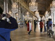 Visitors pose inside the Hall of Mirrors in the Versailles castle in Versailles, west of Paris, on Nov. 17, 2015. Rick Steves’ summer travel tips include getting tickets in advance for major attractions so you can skip the line and avoid the crowds.