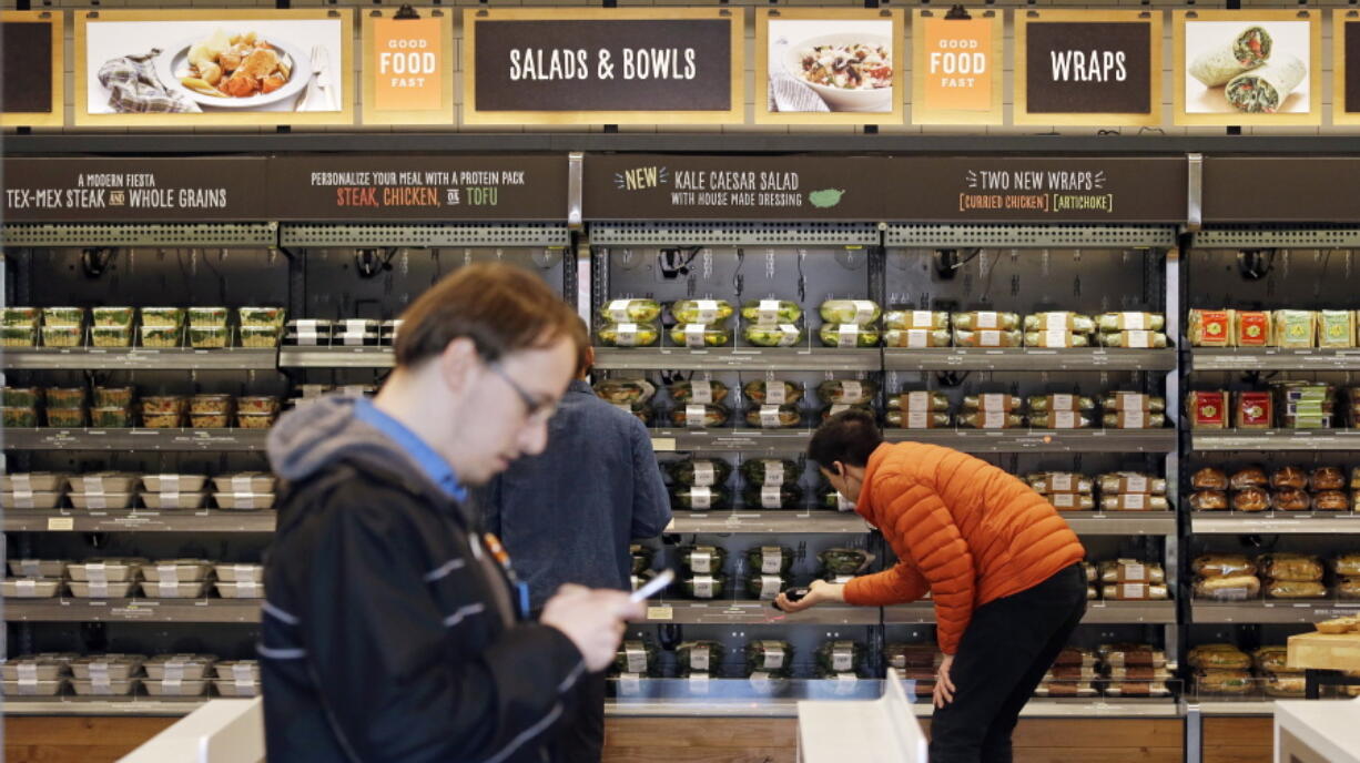 Shoppers roam an Amazon Go store, currently open only to Amazon employees, in Seattle.