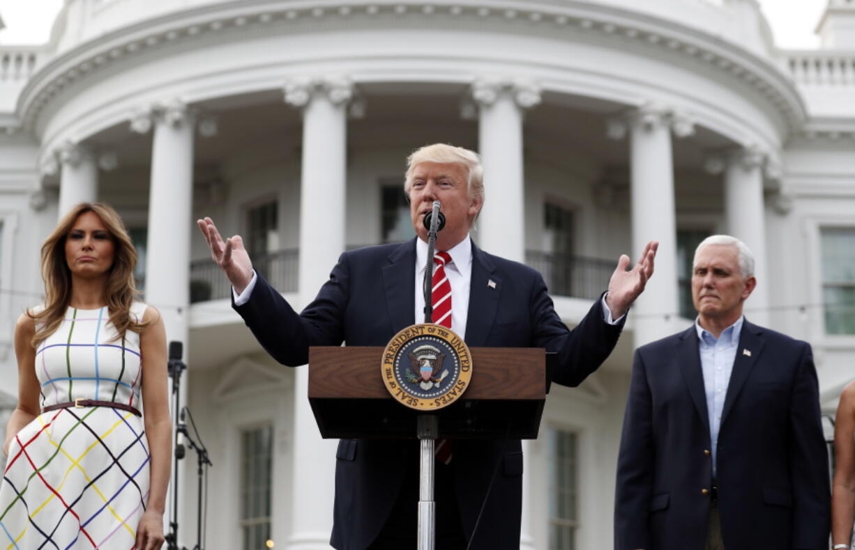 President Donald Trump, center, speaks as first lady Melania Trump and Vice President Mike Pence listen at the Congressional Picnic on the South Lawn of the White House, Thursday, June 22, 2017, in Washington.