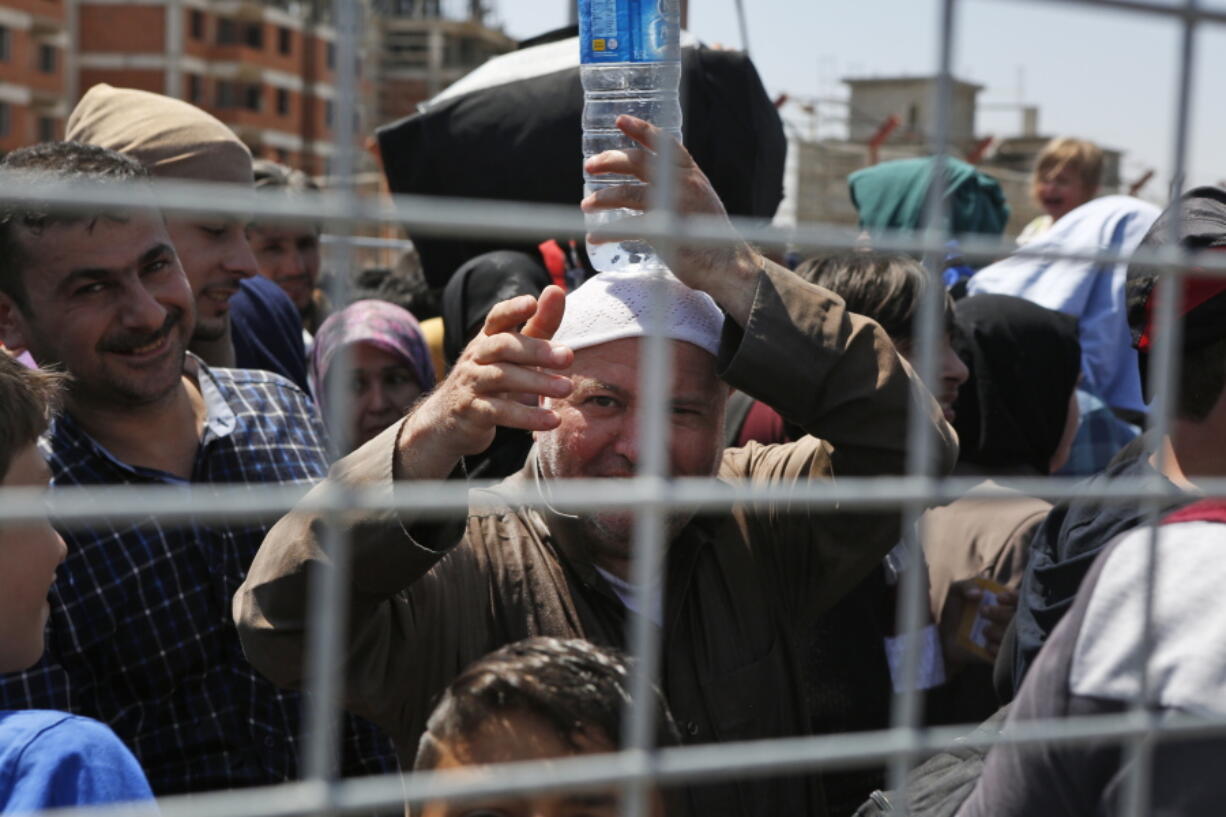 Syrians living in Turkey wait to cross into Syria at the Oncupinar border crossing, near the town of Kilis, Turkey. Thousands of Syrians are returning home for the holy month of Ramadan as Turkey temporarily opens two border crossings. The border has been closed for security concerns caused by the ongoing Syrian war and only opens under special circumstances.