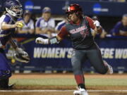 Oklahoma’s Fale Aviu avoids the tag of Washington’s Morganne Flores in the second inning of a Women’s College World Series in Oklahoma City, Friday.