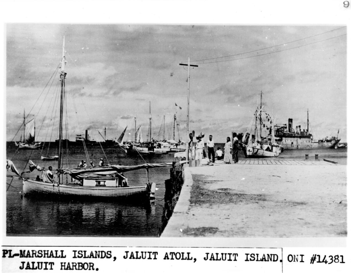 This photo, possibly showing Amelia Earhart, is the subject of a History channel documentary. Earhart may be the person sitting on the dock in the white shirt.